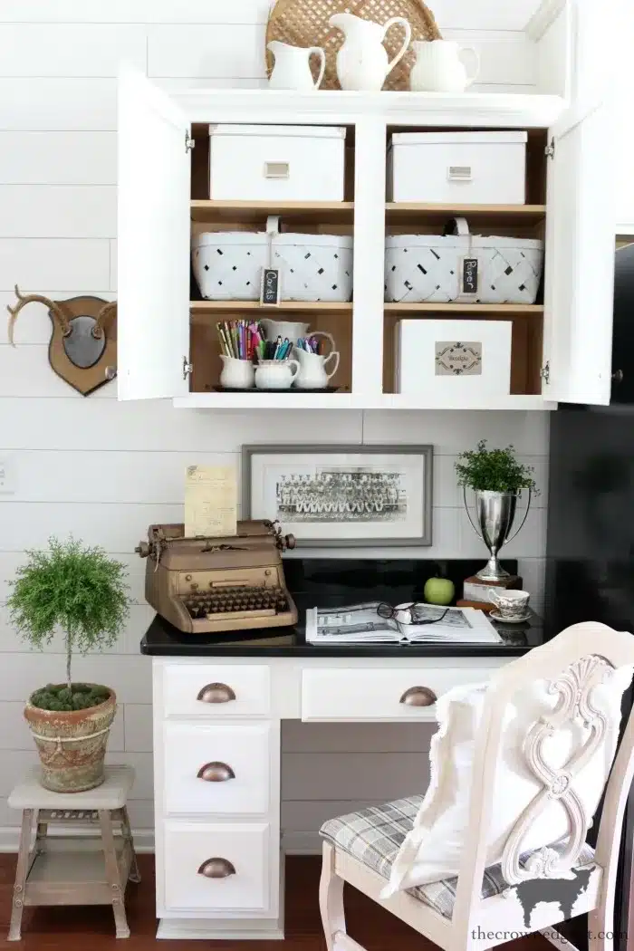 kitchen desk with cabinets overhead.