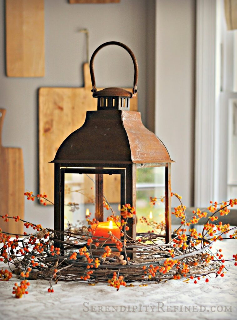 rustic lantern wrapped in grapevine and berry sprig