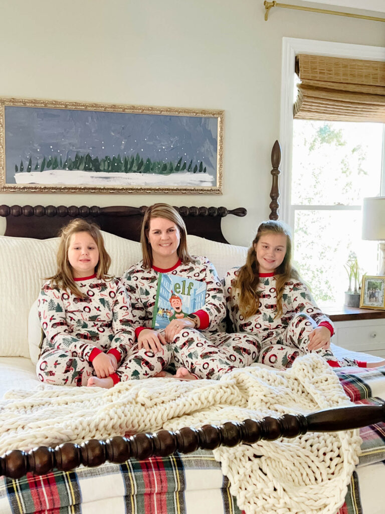 mom and daughters in christmas pjs on the bed