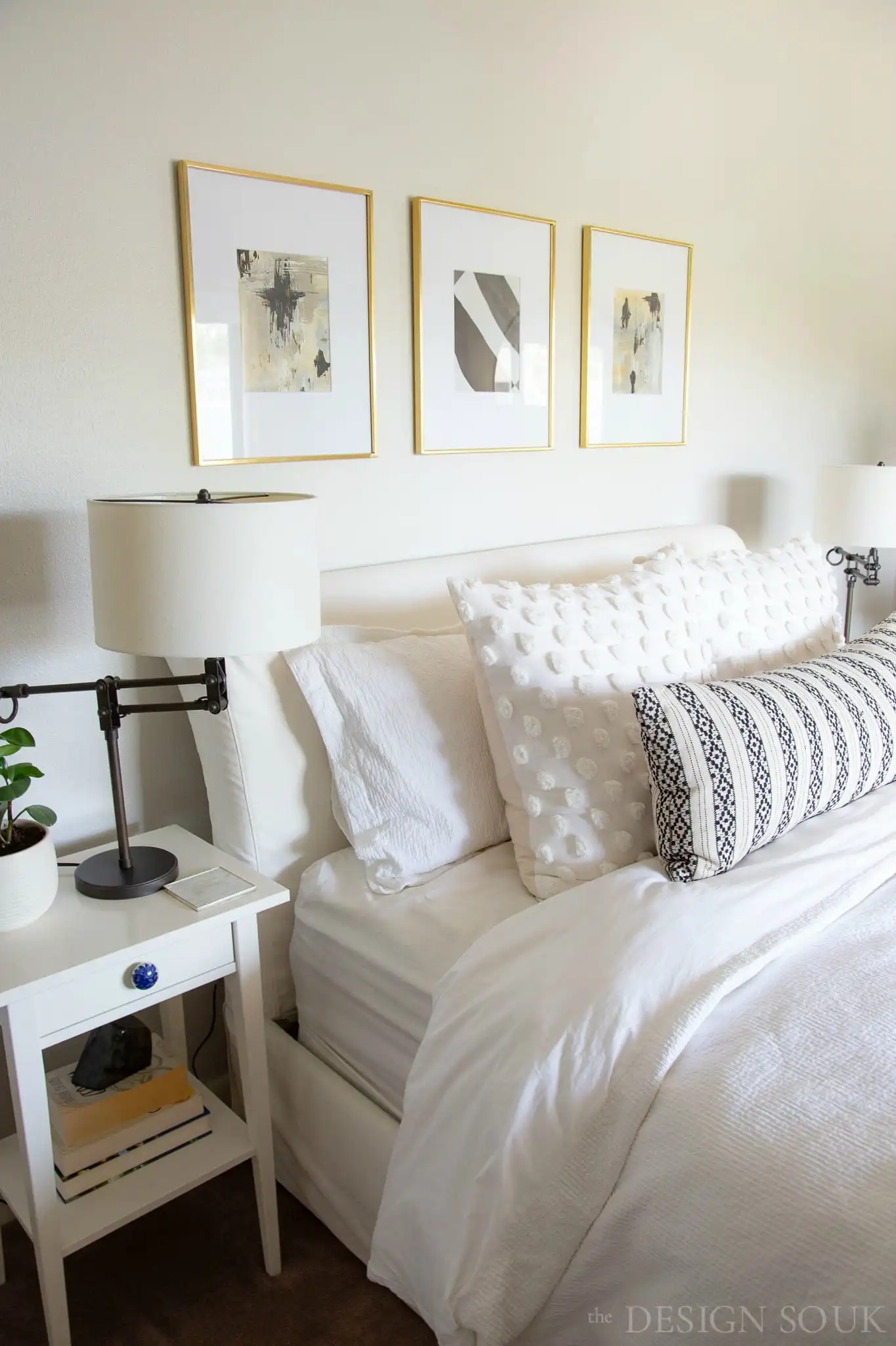 white linen bedding on an upholstered bed in a guest room