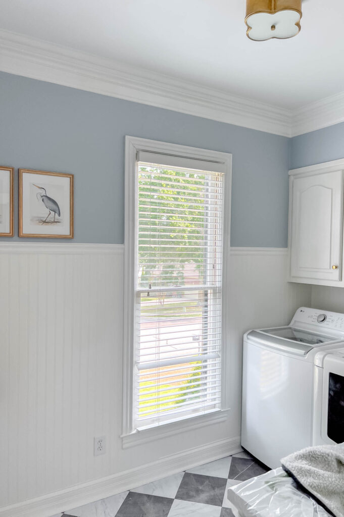 Laundry room with blue walls and white beadboard.