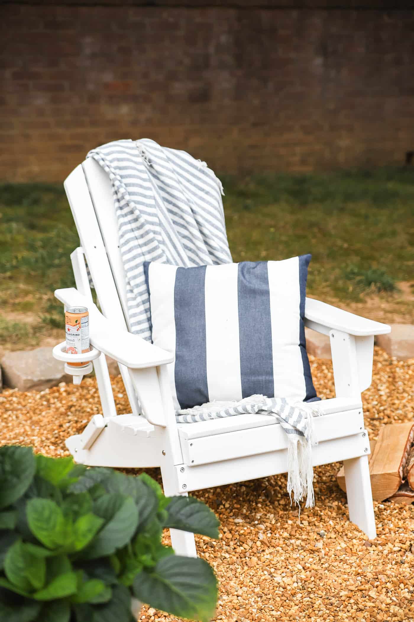 white adirondack chair with striped navy and white pillow