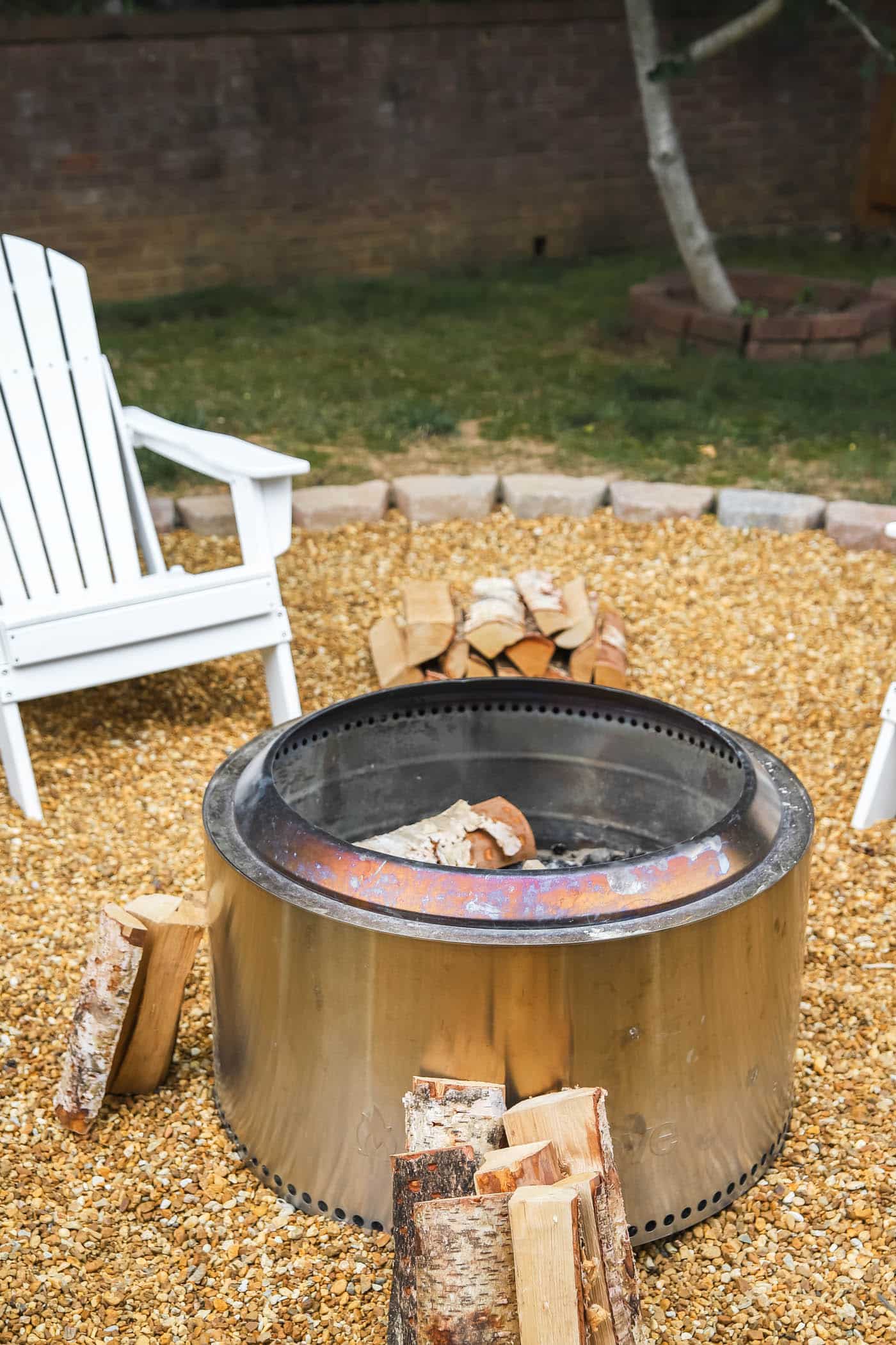 Yukon Solo Stove with fire wood on a pea gravel fire pit. 
