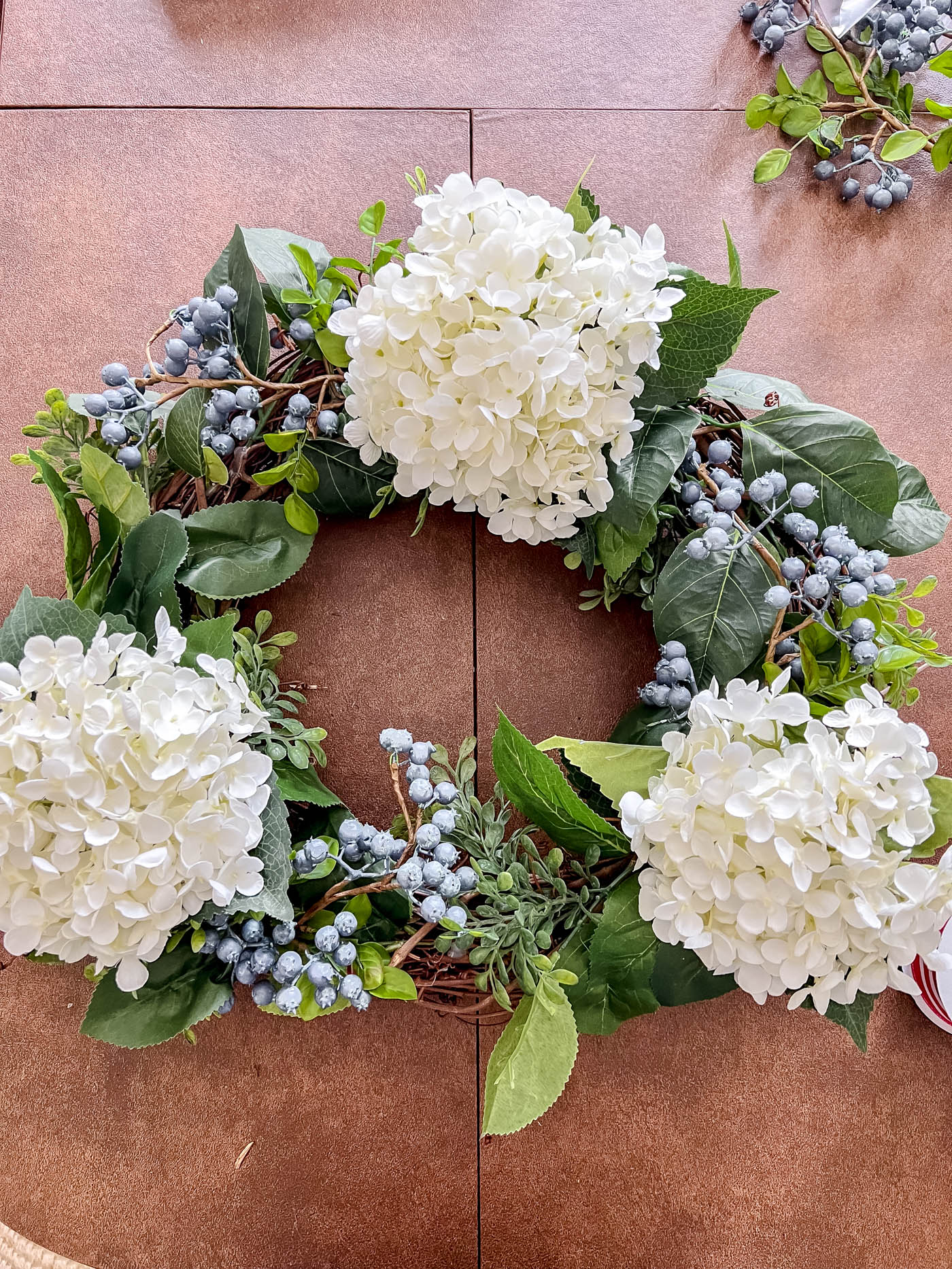 Add blueberry stems to patriotic wreath