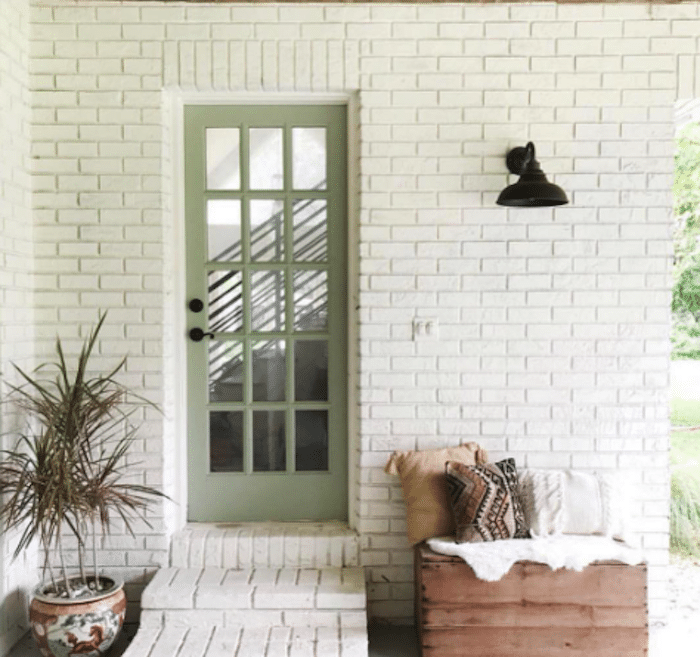 white brick exterior with Sherwin Williams Clary Sage painted door.