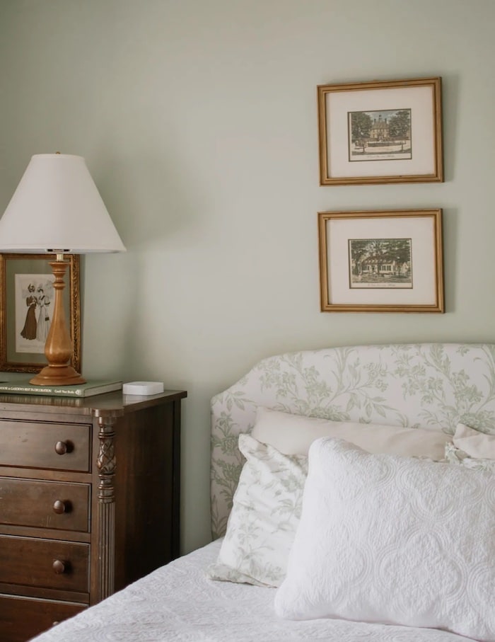 bedroom with Benjamin Moore Hollingsworth Green walls, upholstered bed with toile headboard and dark wood dresser for a nightstand.