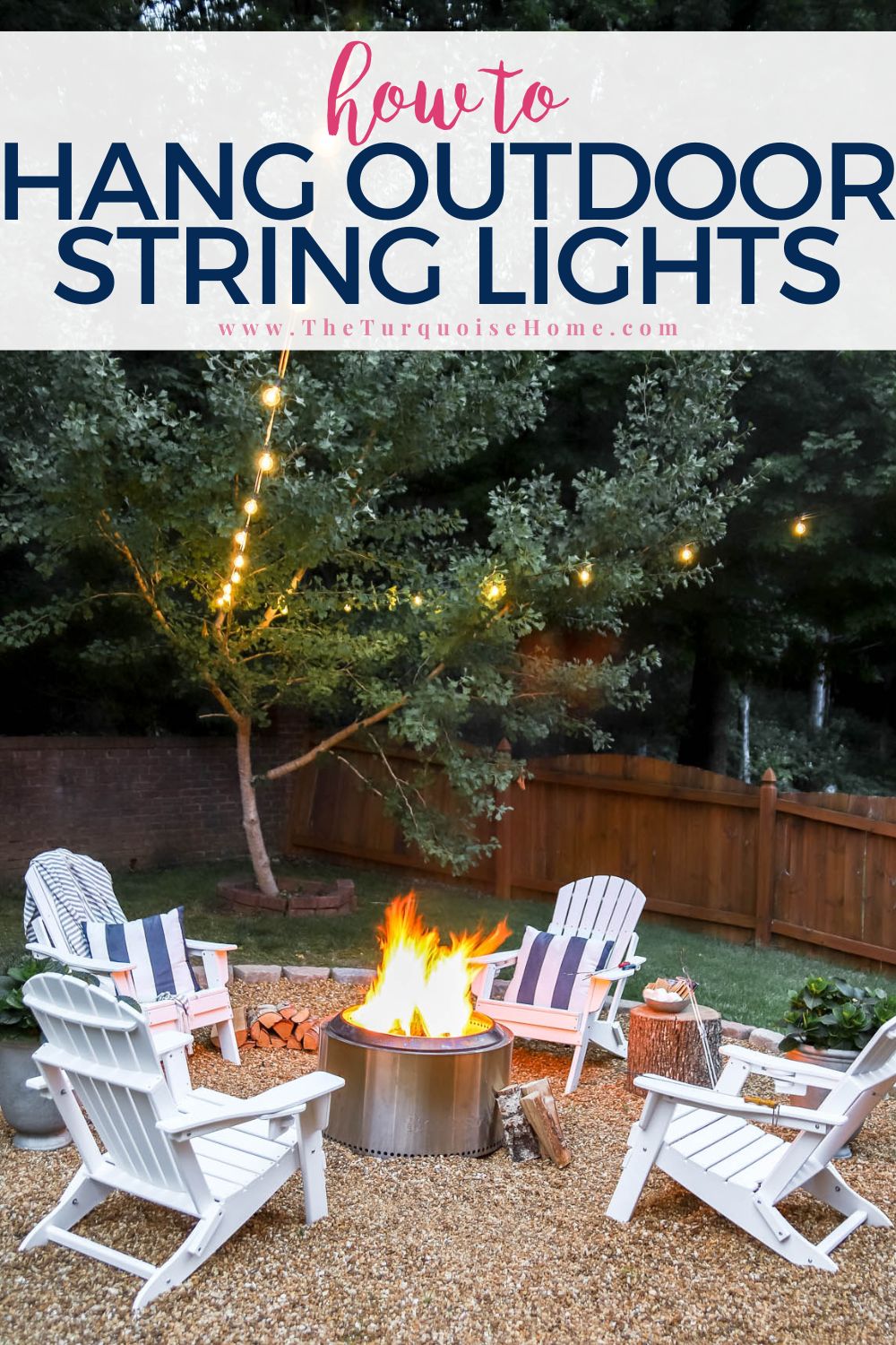 Warm string lights hanging over a fire pit area with white Adirondack chairs. 