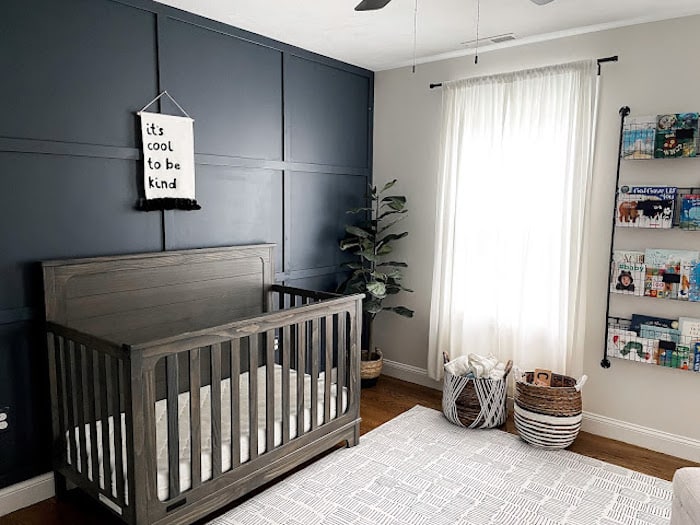 Boy's nursery with Hale Navy accent wall and wood crib.