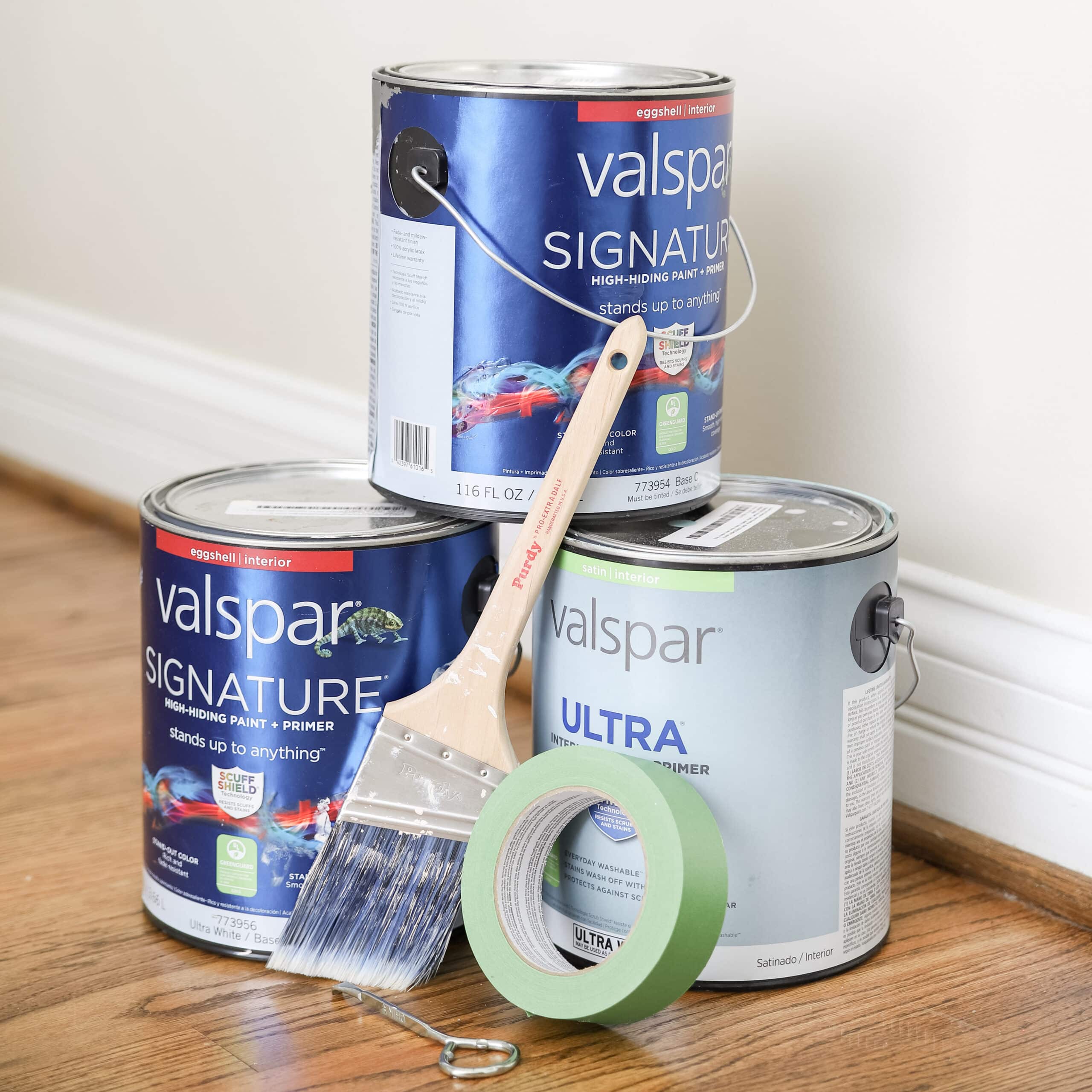 paint cans, paint brush, painters tape and paint can opener