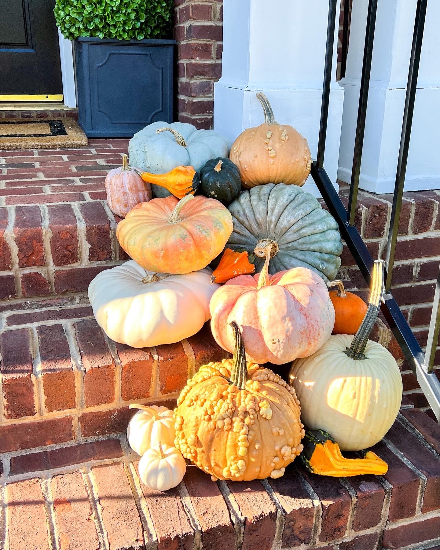 real pumpkins on fall front porch brick steps.