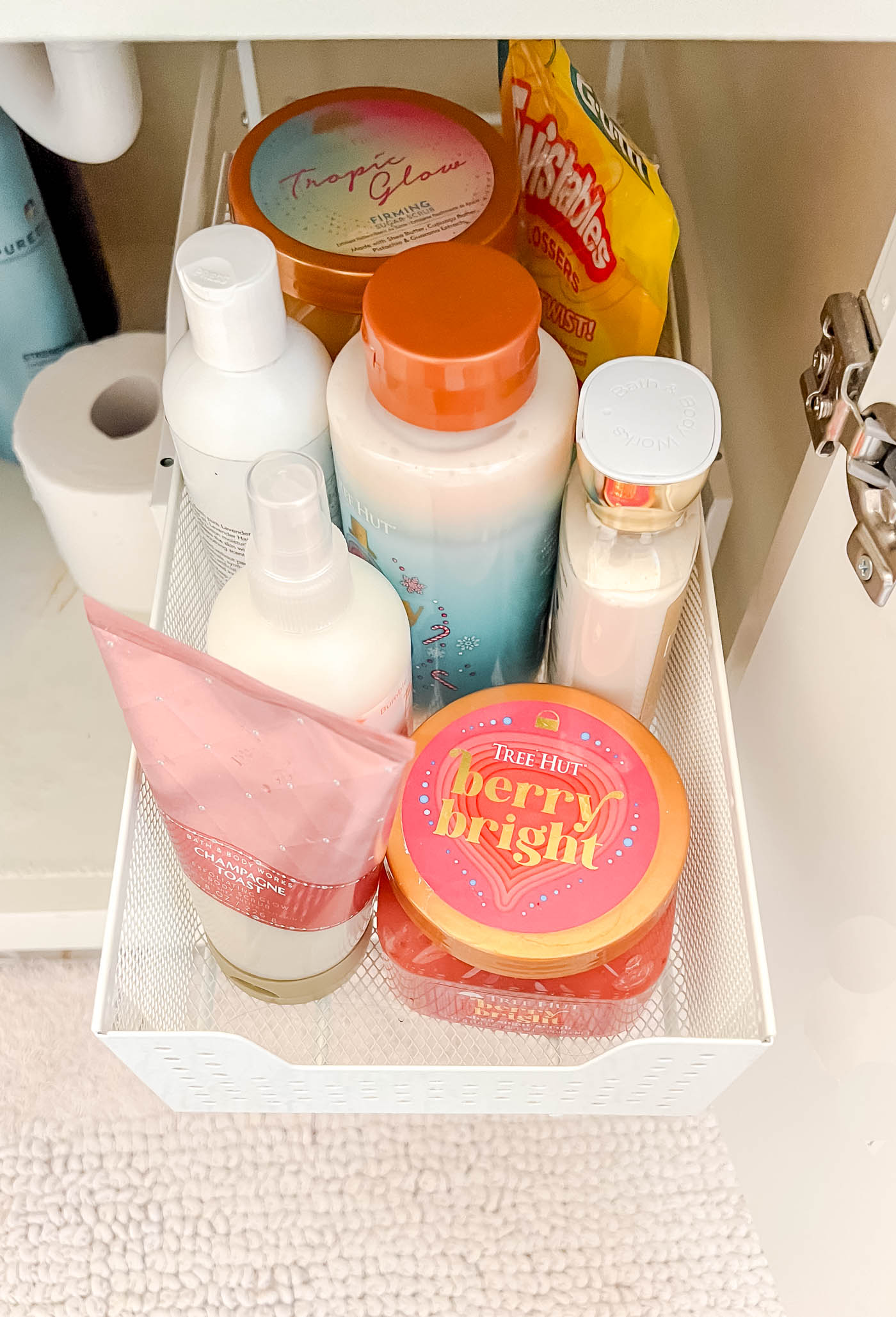 lotions and other Beaty products in bottles in a sliding drawer organizer