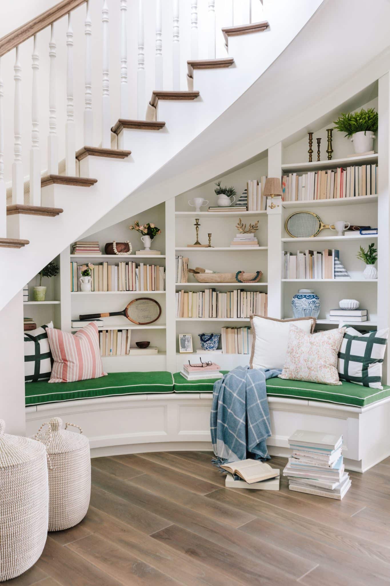 cozy under the stairs reading nook with built-in bench and green bench cover