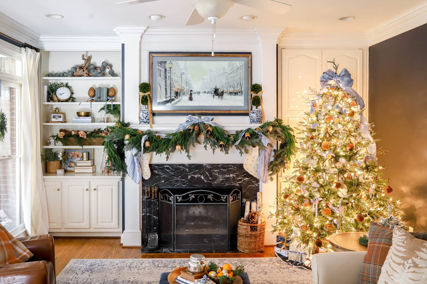 pretty christmas living room mantel with garland and a frame tv.