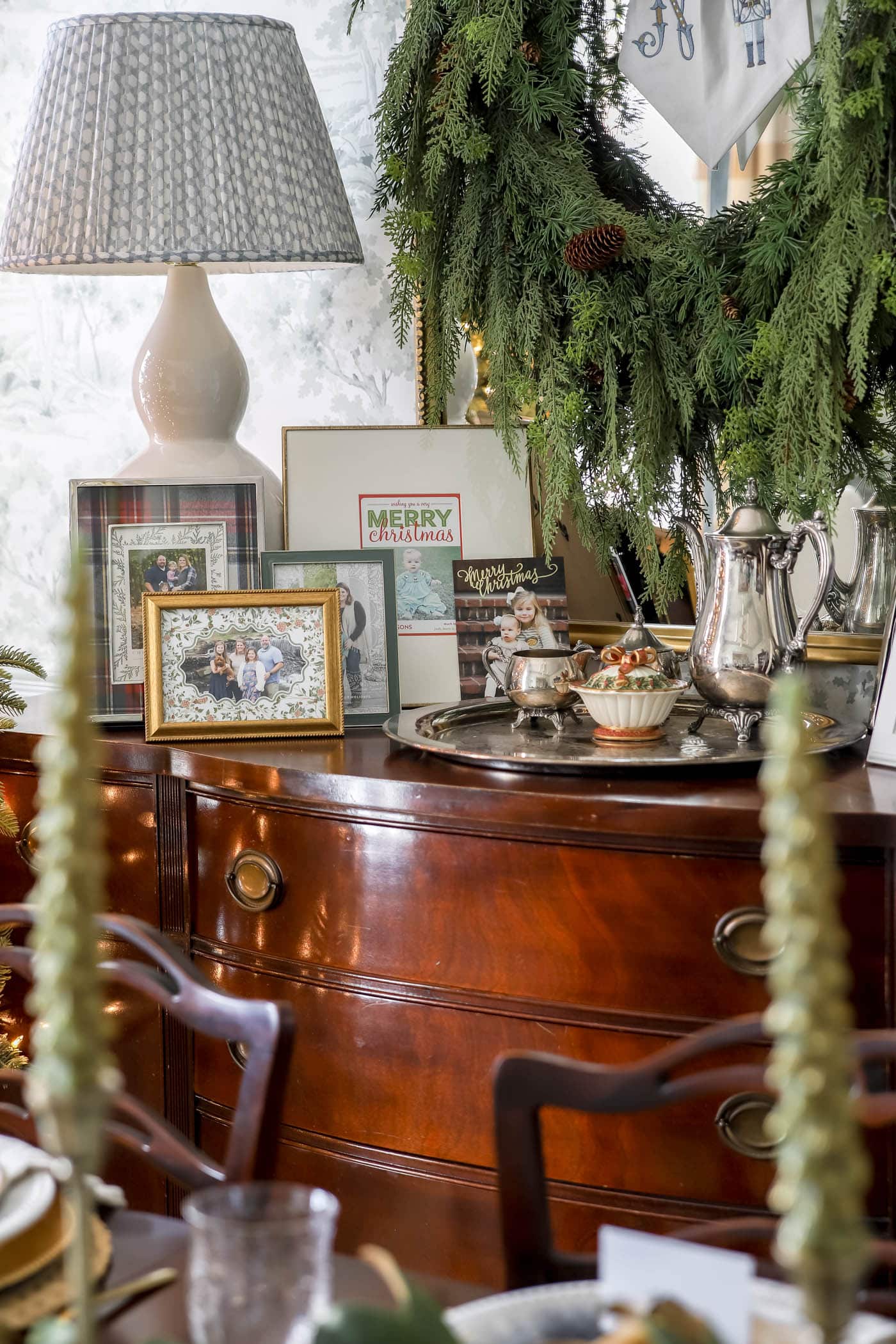 Christmas dining room buffet with framed Christmas cards displayed.
