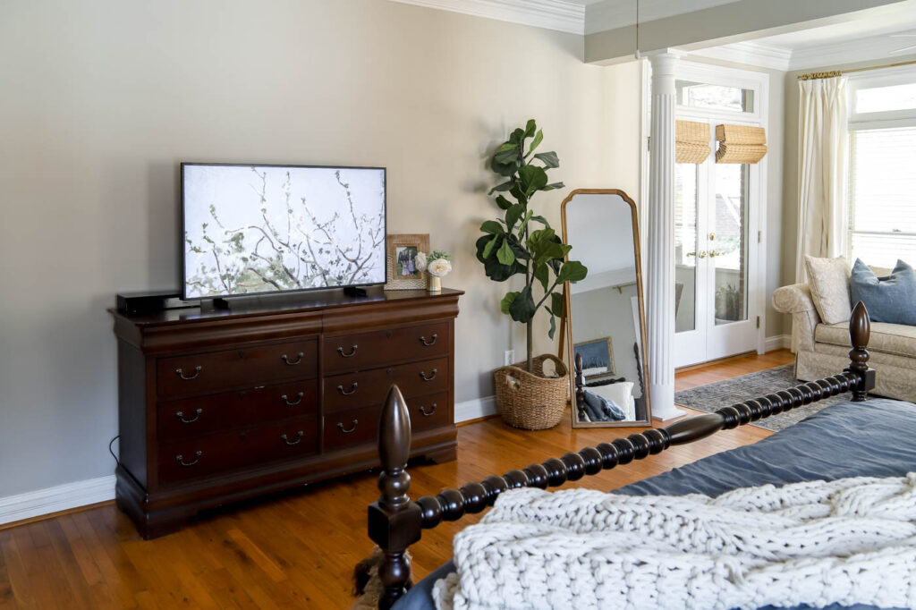 a sleeping corner with a smaller mirror and a large fig tree.