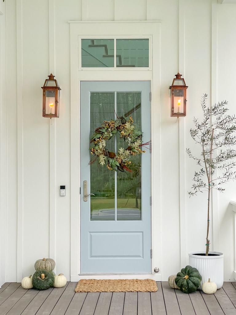 copper lanterns flank front door on coastal fall porch