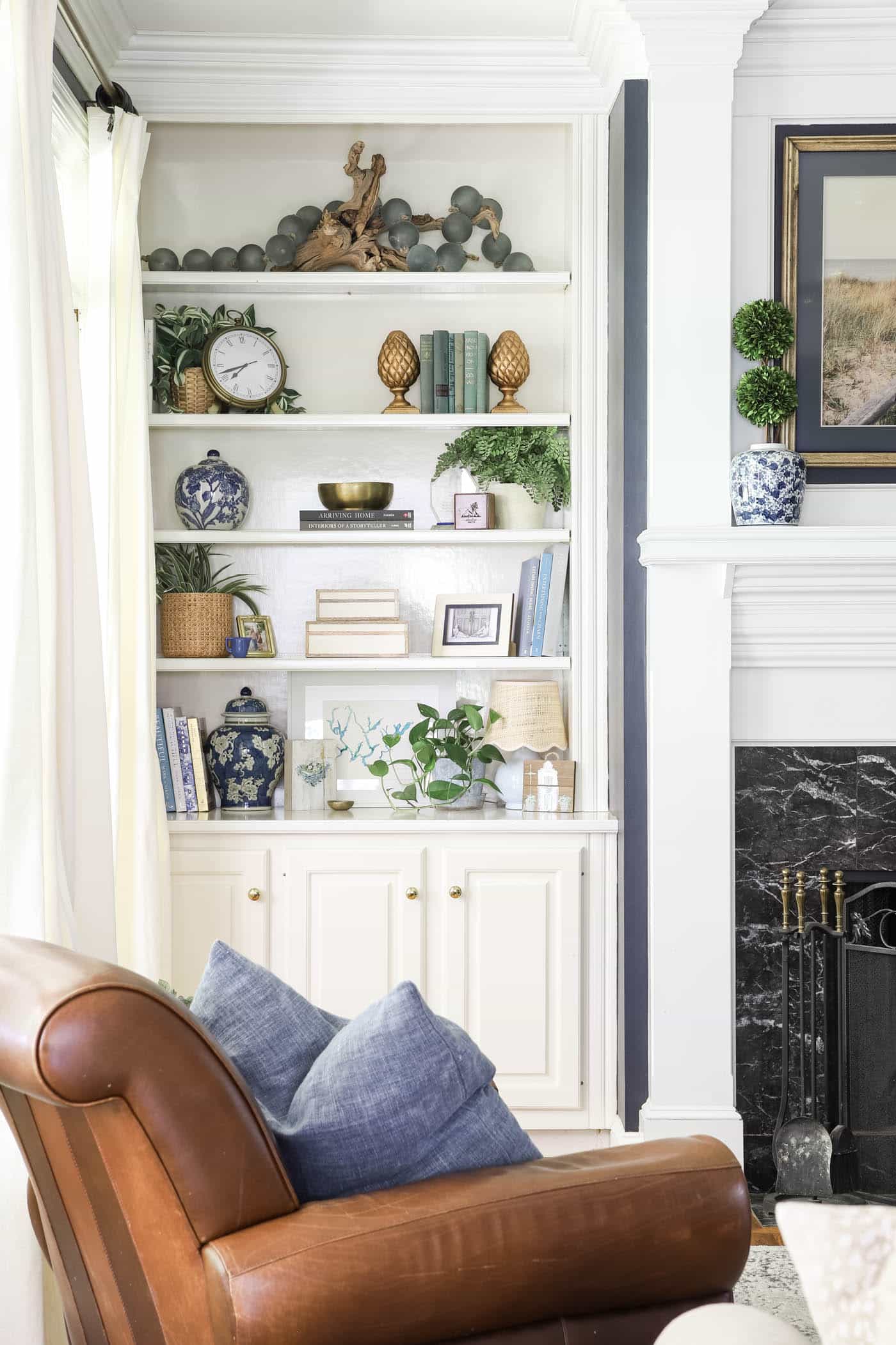 summer built-in bookshelf decor in a white and blue living room.
