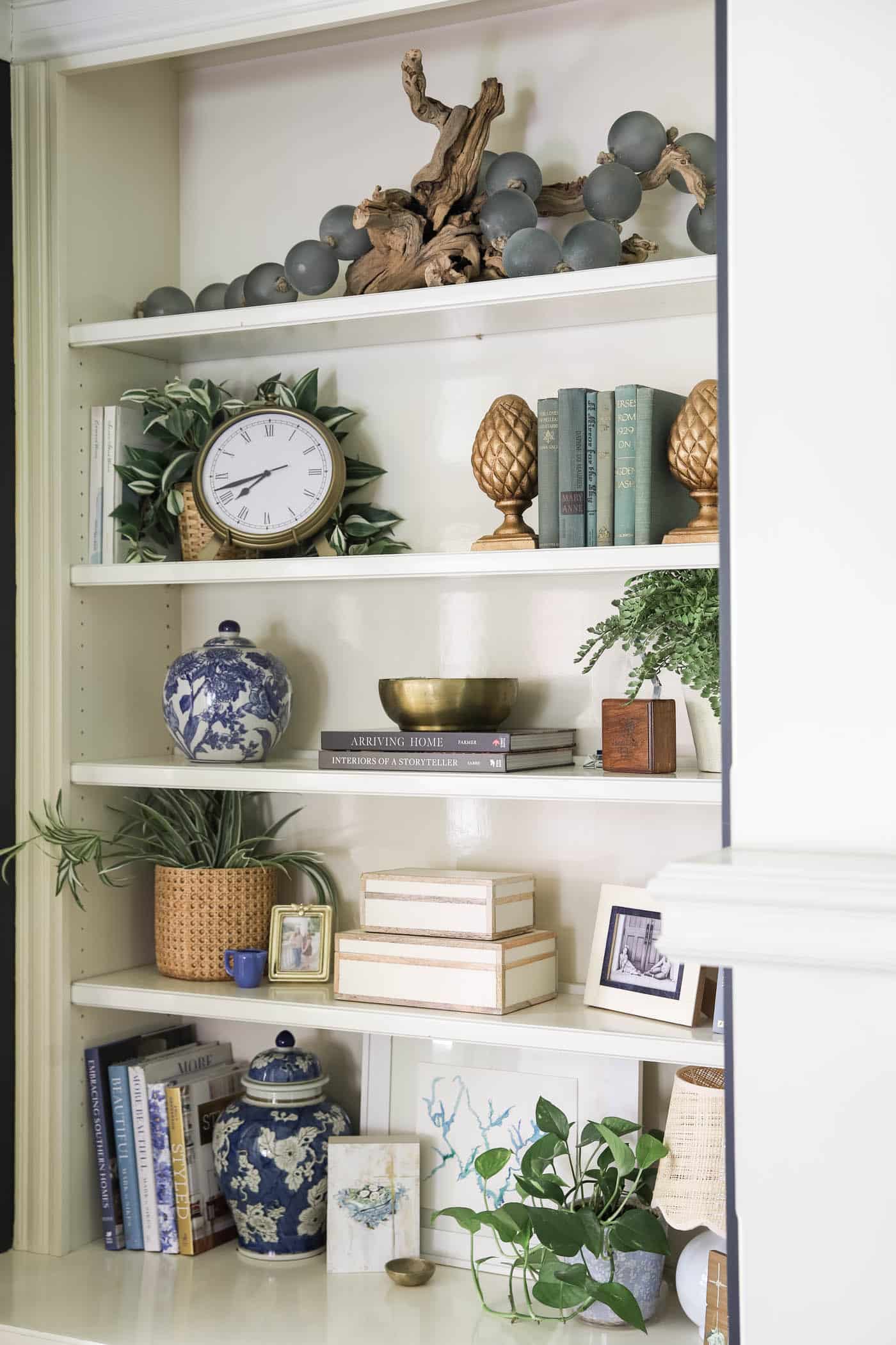 layering art and decorative objects on a bookshelf.