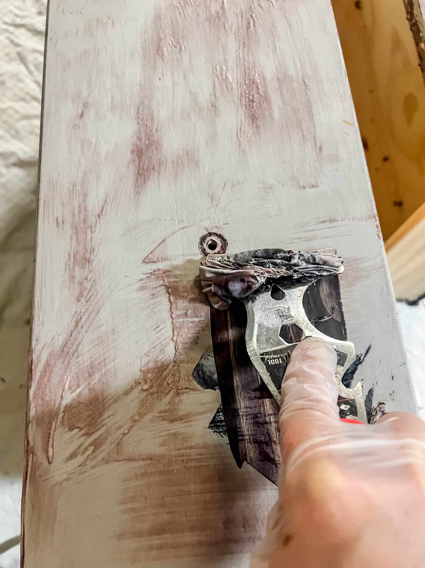 removing paint with a scraping tool.