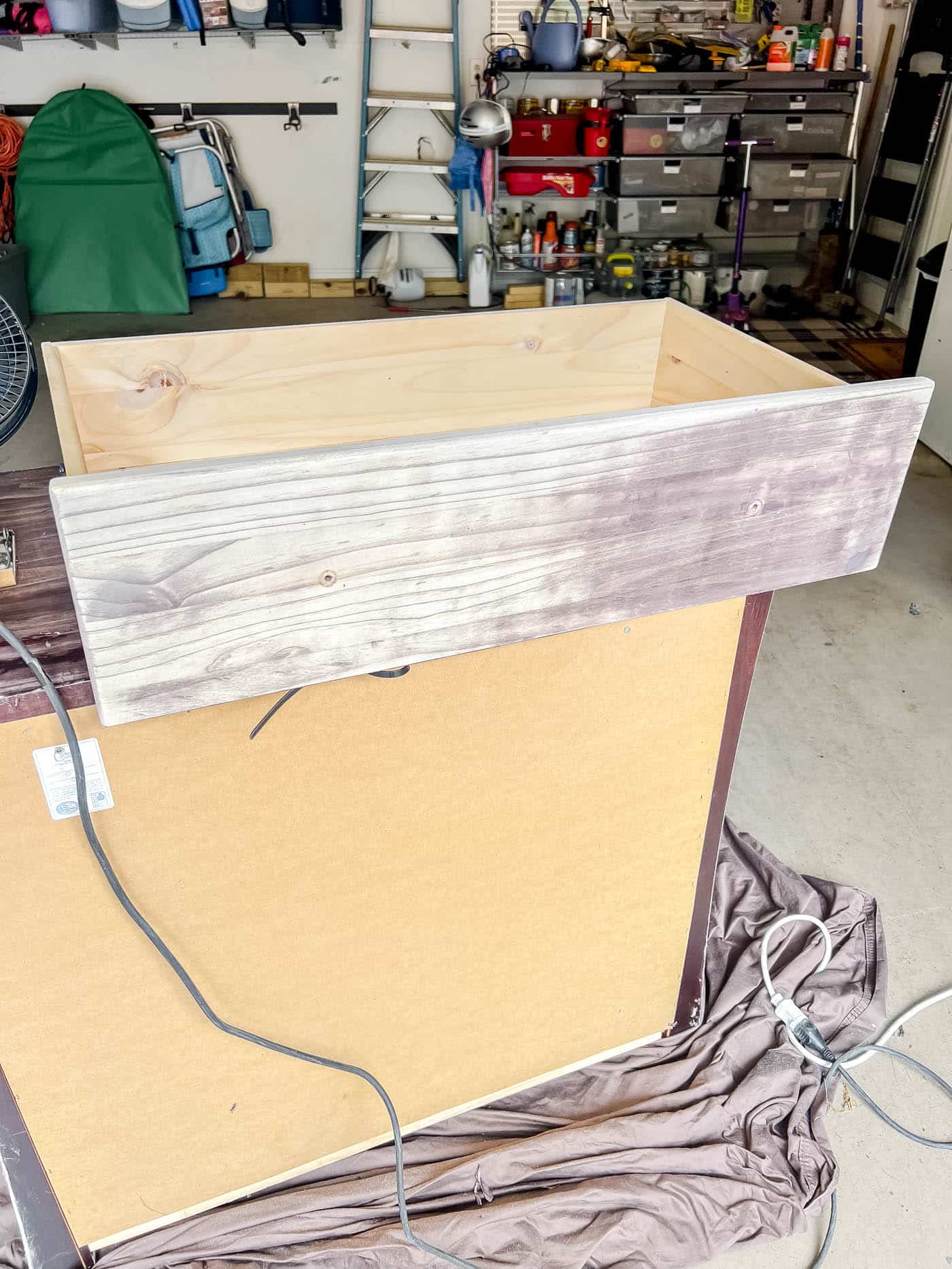 sanding down the drawers with a sheet sander.