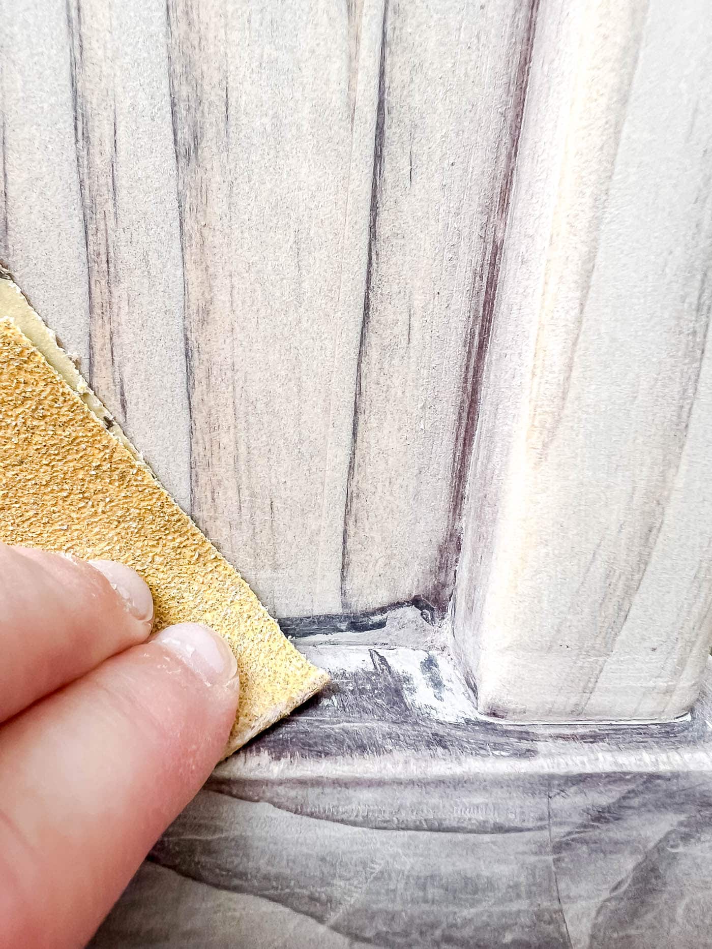 sanding the corners for refinishing wood furniture.