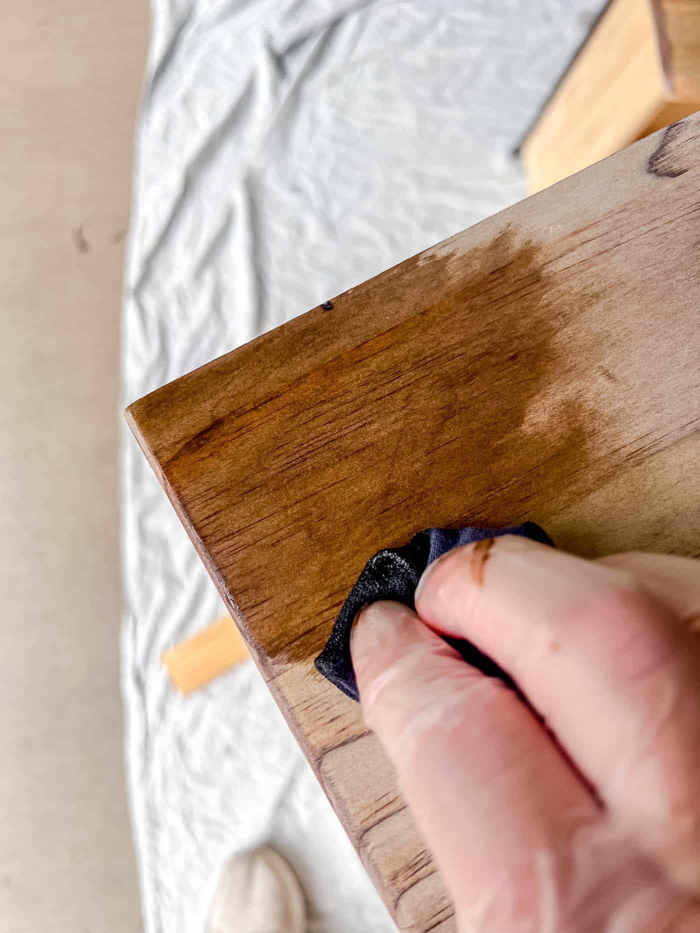 applying stain to a piece of wood furniture.