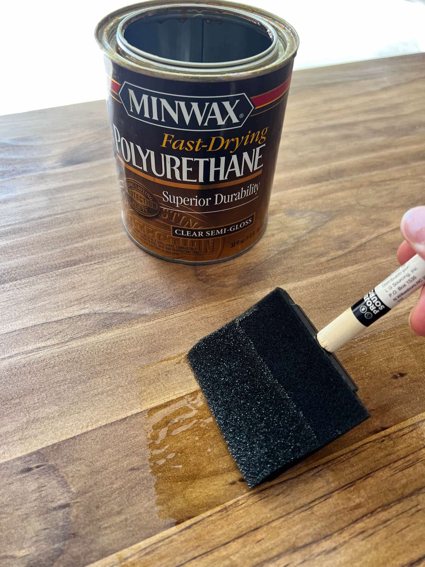 applying a top coat to a newly stained piece of furniture.