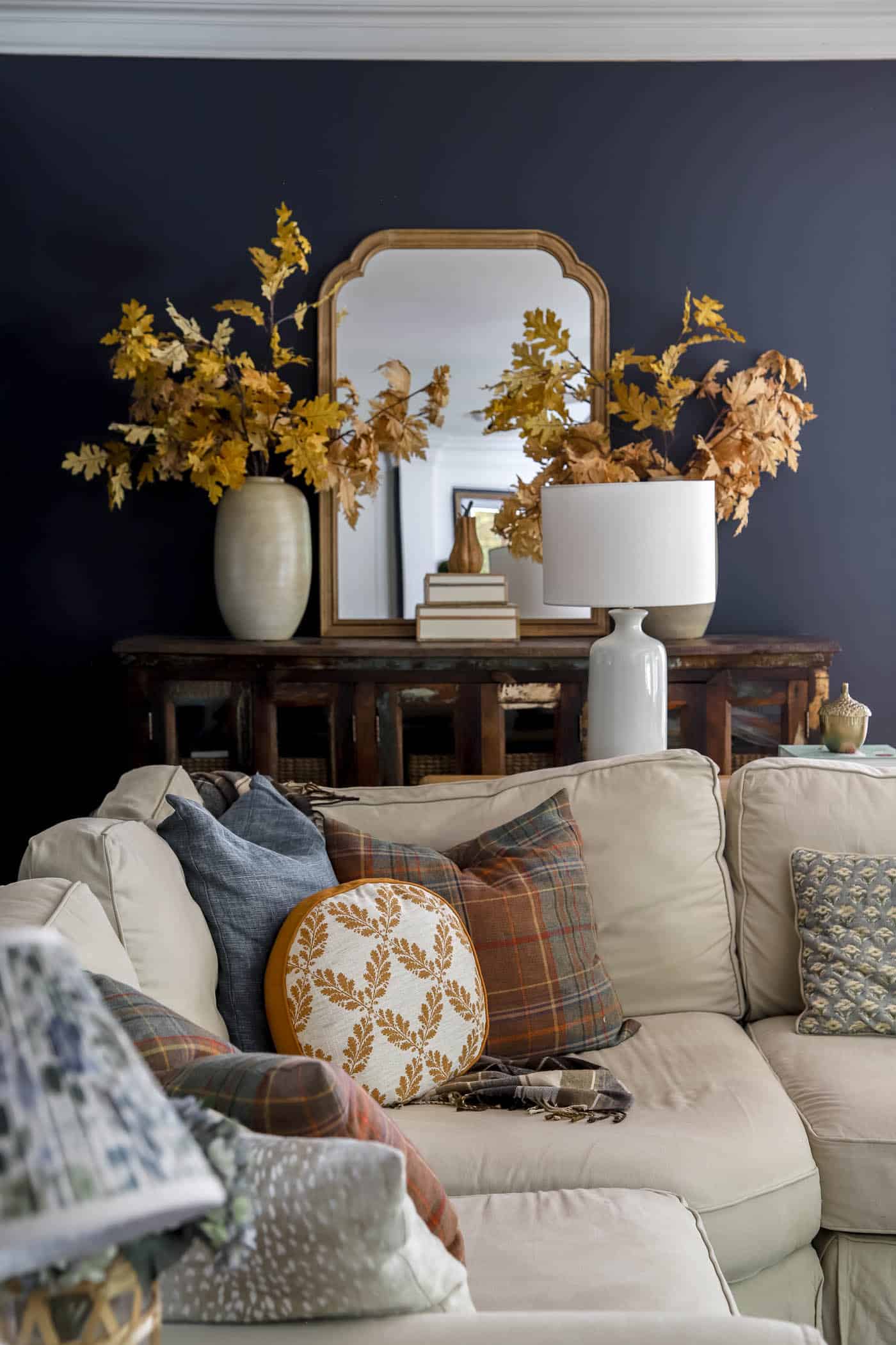 fall pillows in navy living room on a neutral sectional sofa