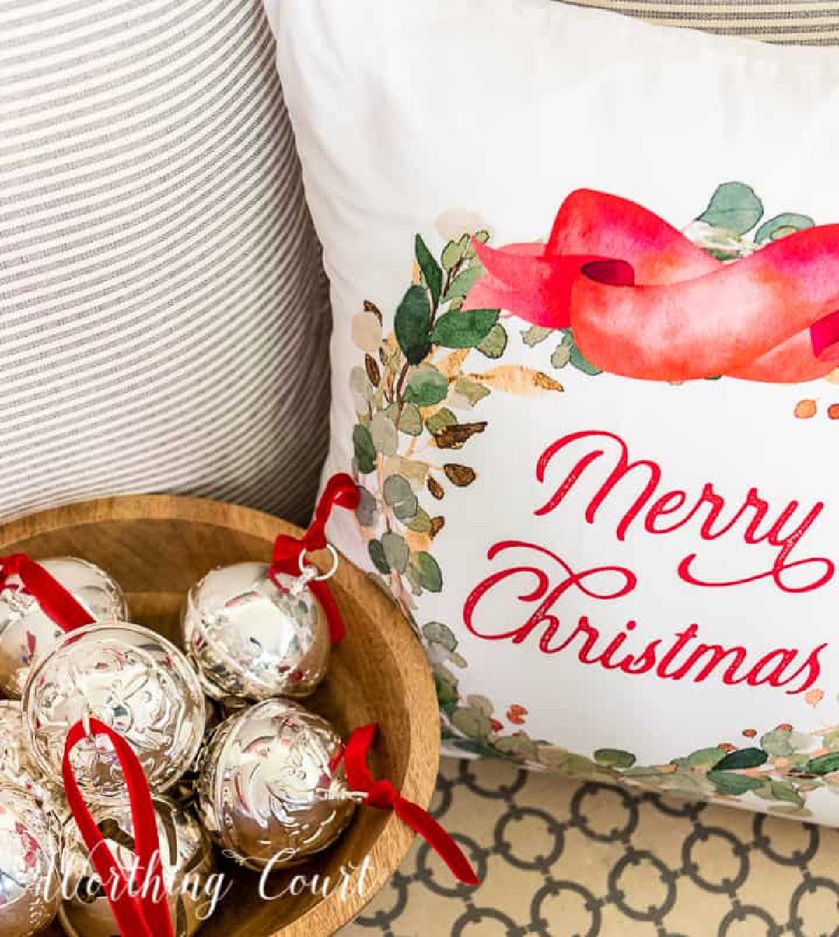 christmas ornaments in a bowl next to a christmas pillow.