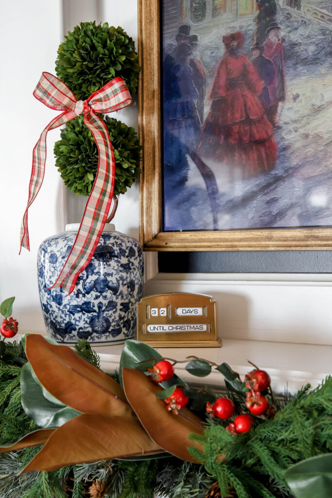 chinoiserie pot with boxwood and ribbon next to a Christmas countdown.