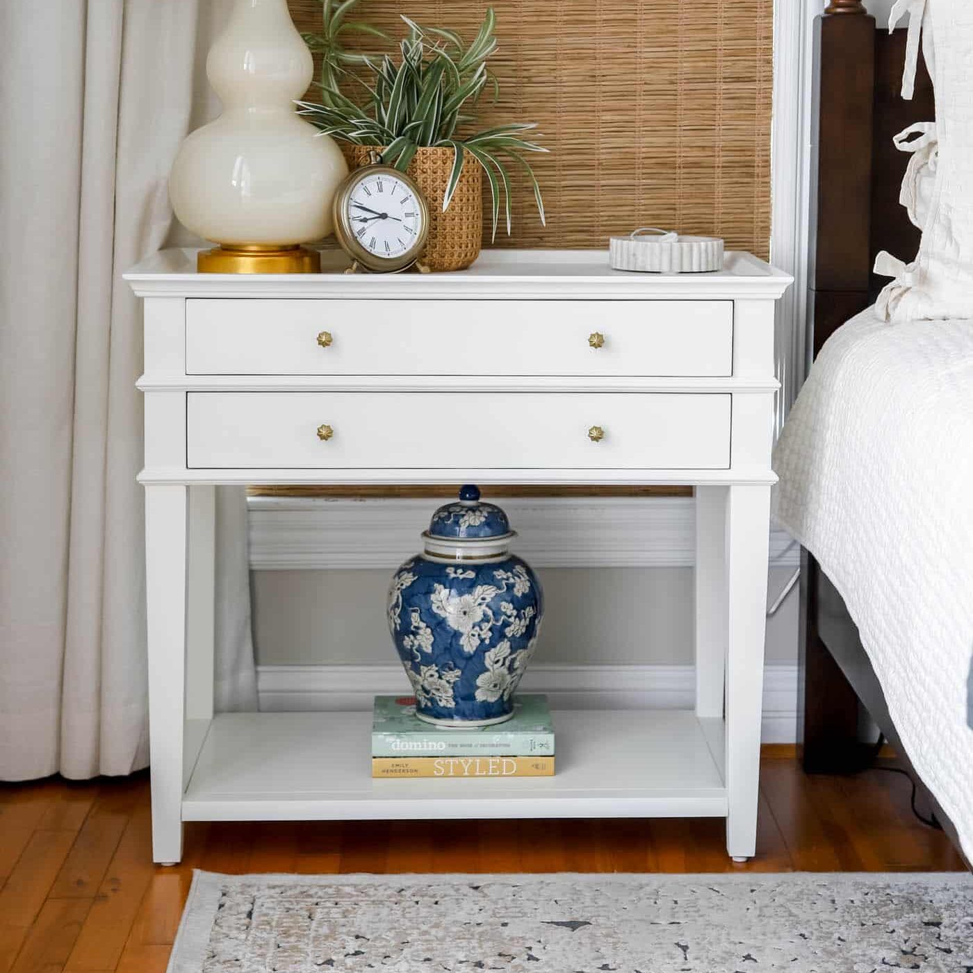 White nightstand with cream lamp and chinoiserie ginger jar.