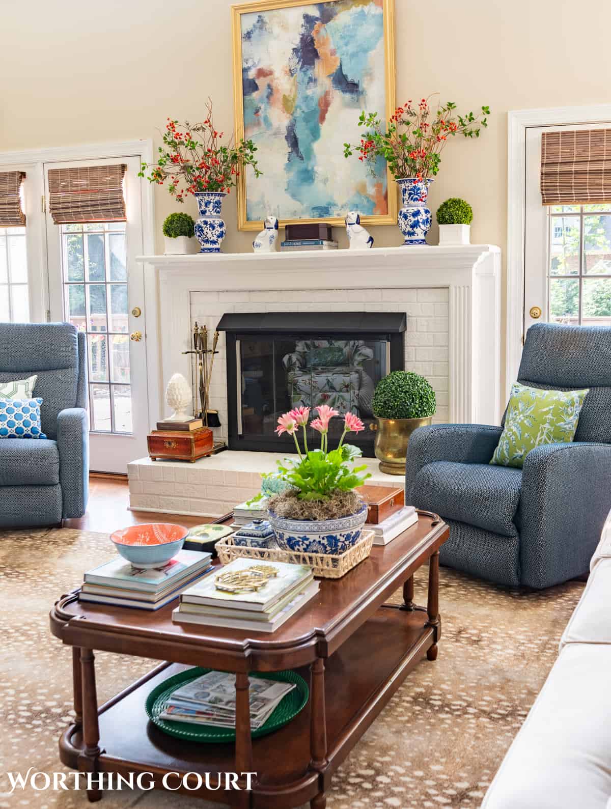 Living room with beige walls, styled fireplace mantel, blue chairs and traditional decor ideas