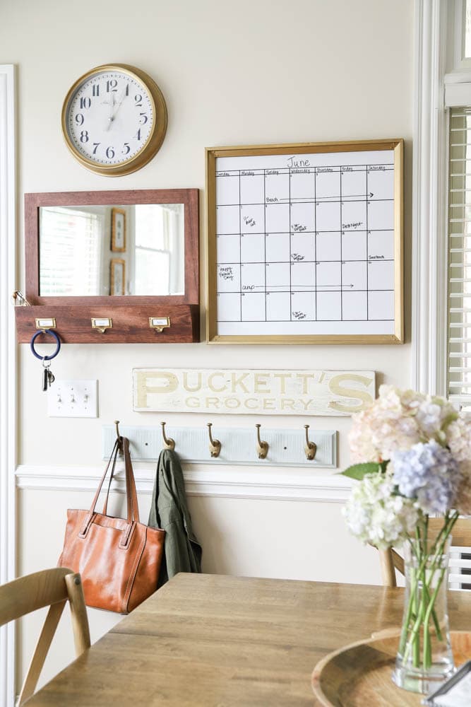 Calendar, mirror, mail sorter and hooks in kitchen area entryway.