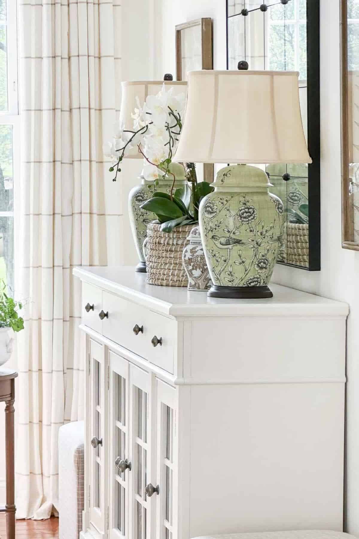 white dresser with chinoiserie lamps on top.