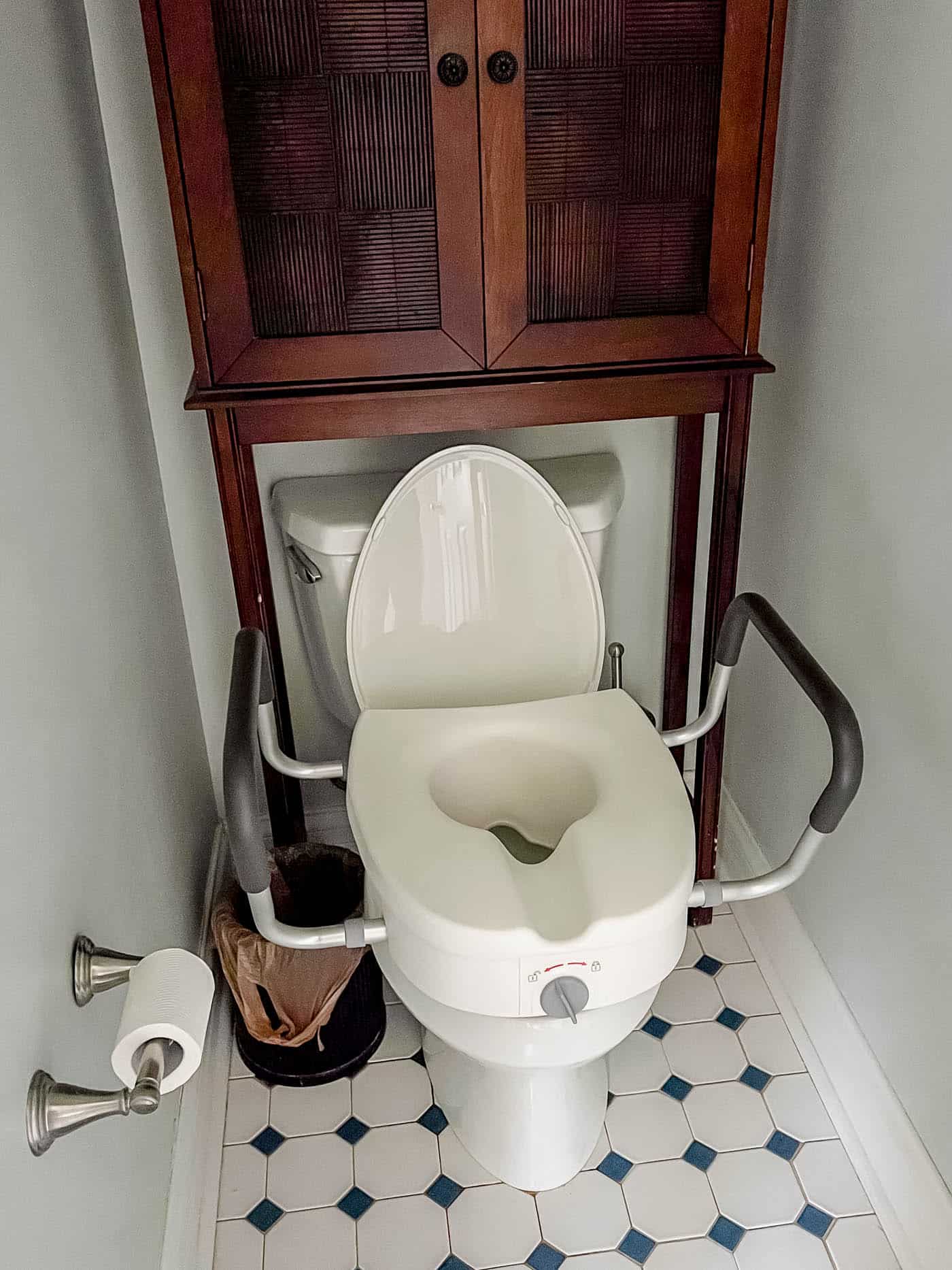 A toilet seat with handles must be raised for recovery after surgery.