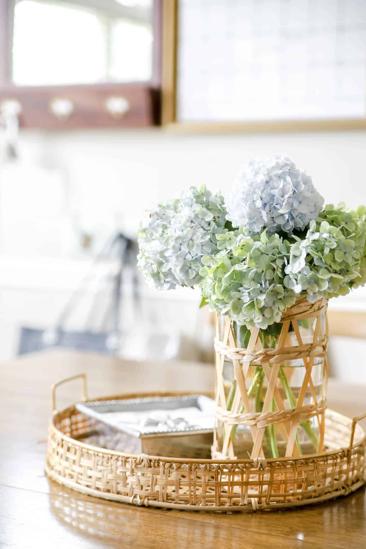 Blue and green hydrangeas in a vase on a wooden table