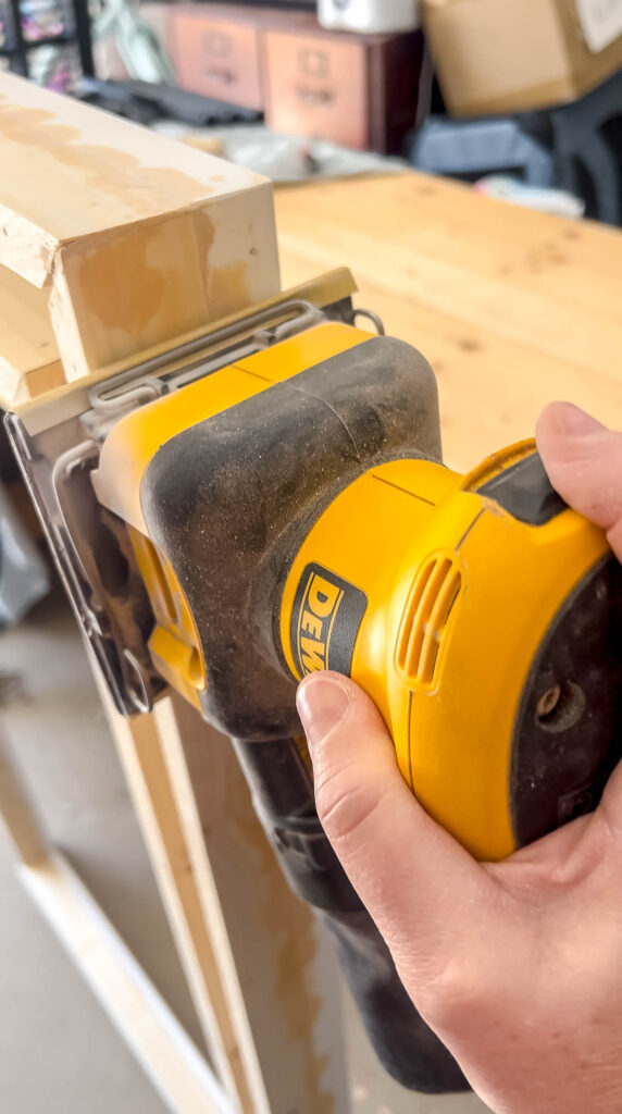 sanding the wood filler on a DIY frame