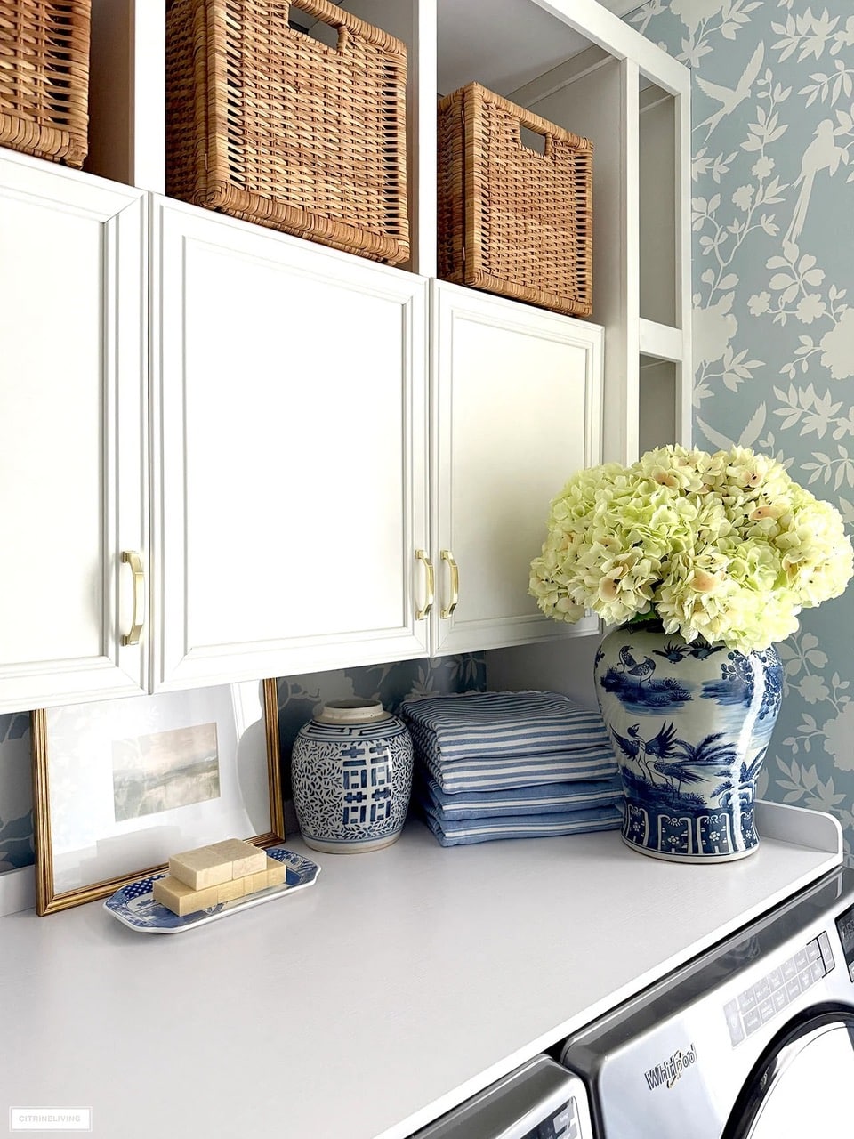 laundry refresh with white cabinets, blue wallpaper and hydrangeas