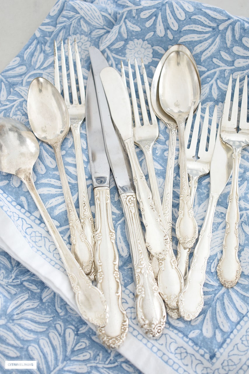 silver utensils on a blue and white napkin
