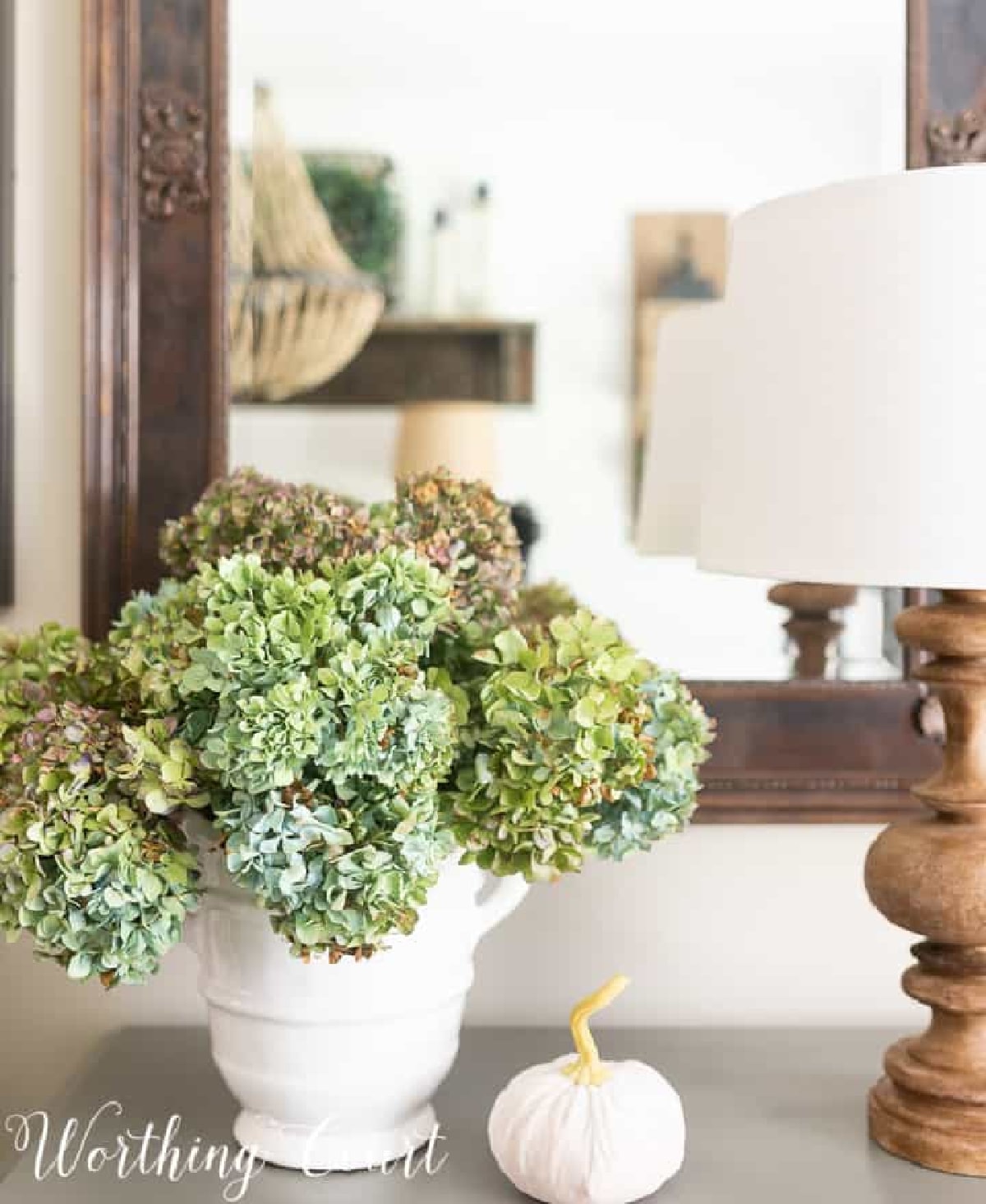 fall pumpkin and blue and green hydrangeas with a wooden lamp